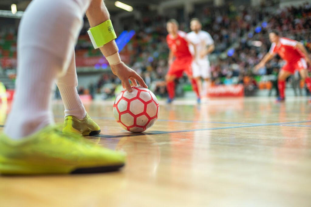 Mecz futsalu - zawodnik ustawia piłkę na boisku